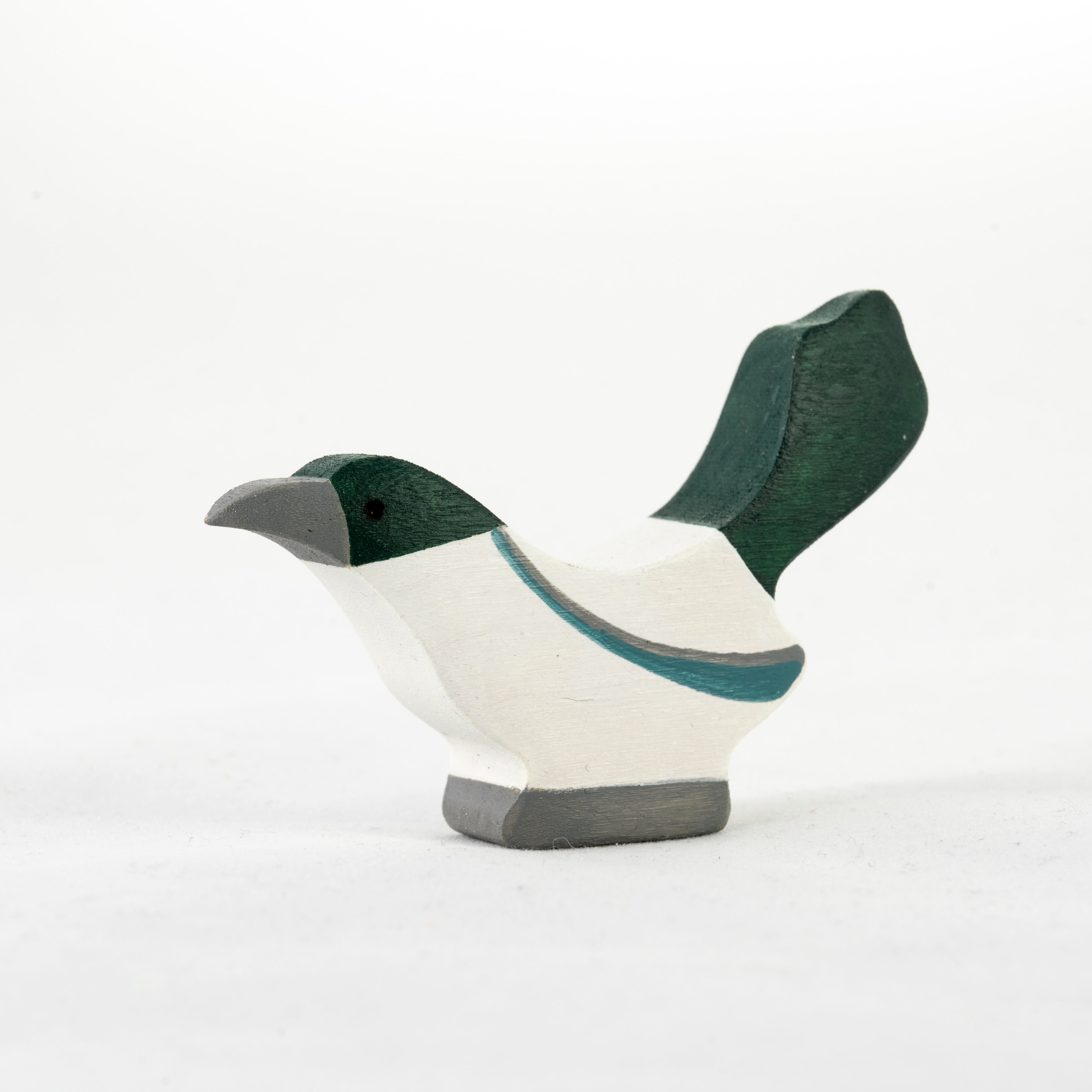 Wooden bird figurine with green and gray details on a white background