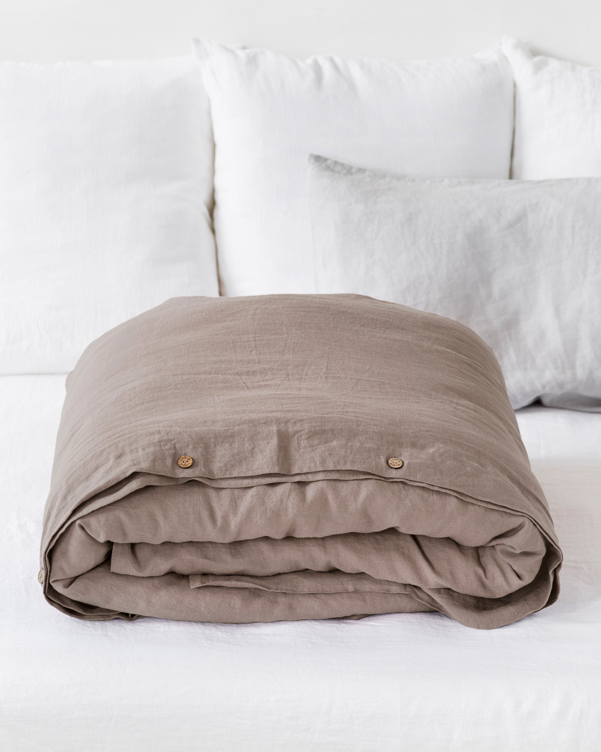 Folded beige blanket on a white sofa