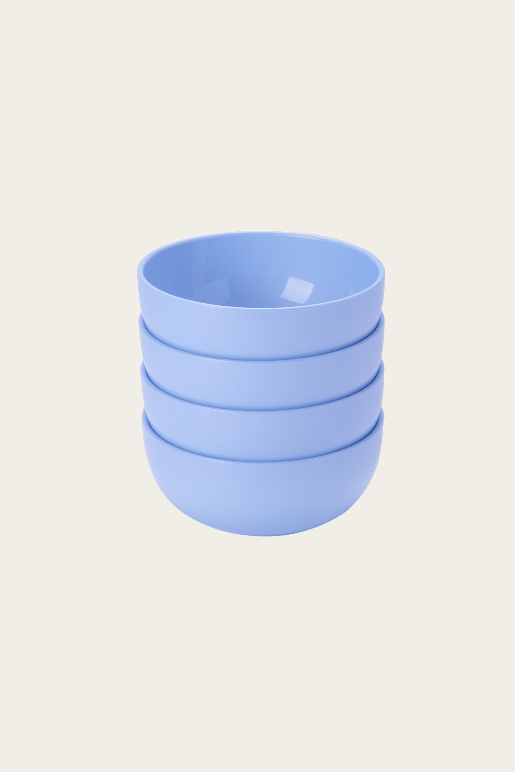 Stack of four light blue ceramic cups on a beige background