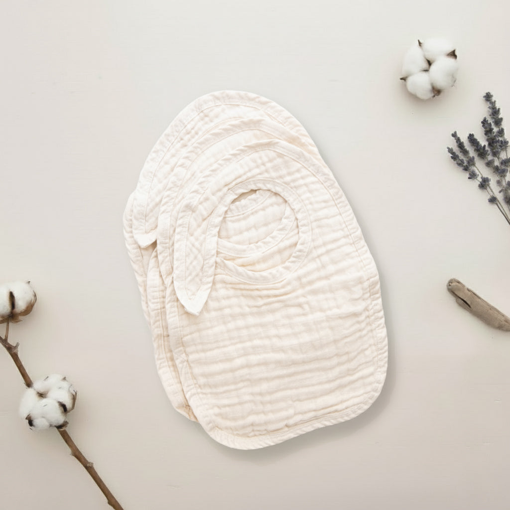 White textured fabric swaddle on a light background with cotton branches