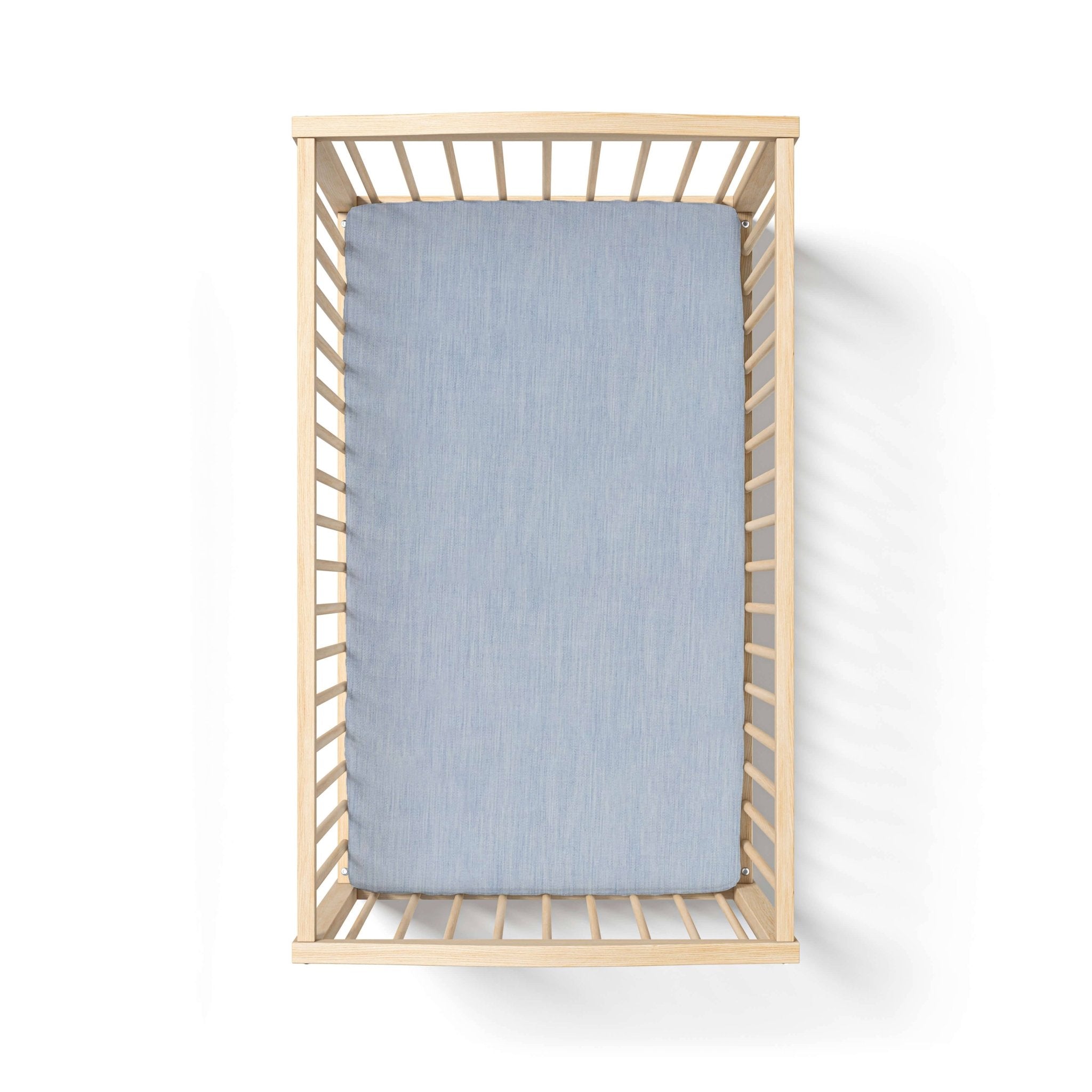 Wooden crib with a blue mattress on a white background