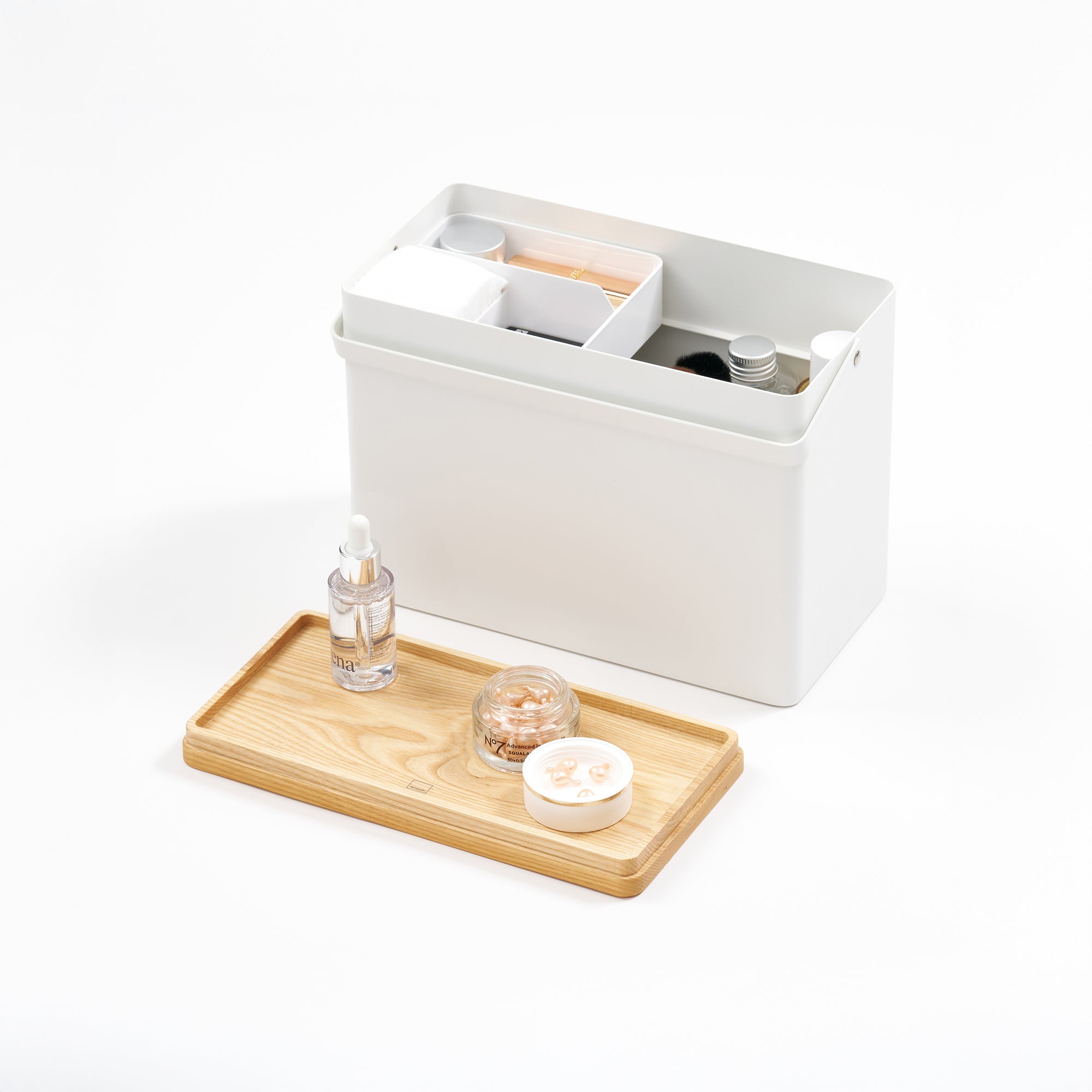 White storage bin with a wooden tray holding small items on a white background