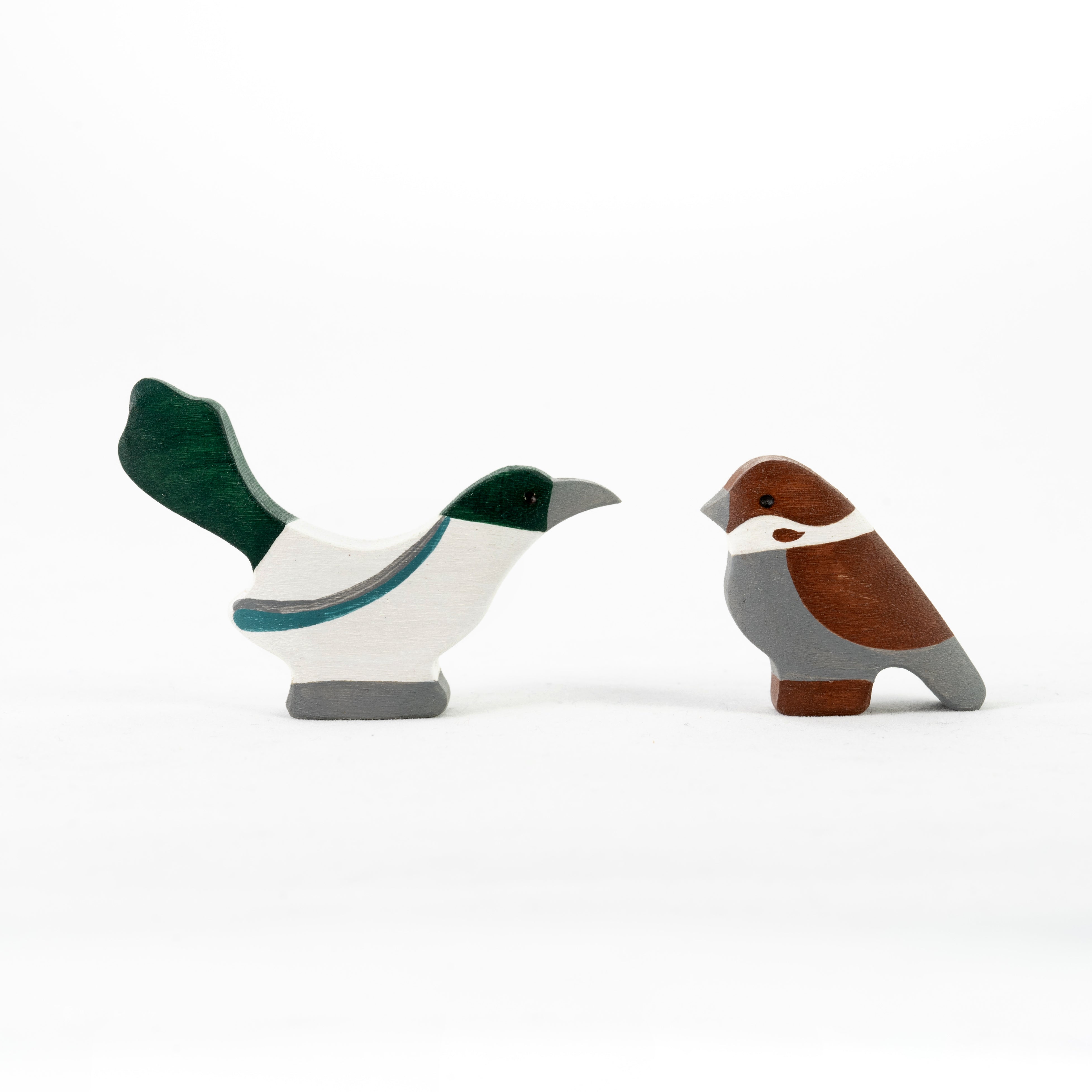 Two wooden bird figurines on a white background