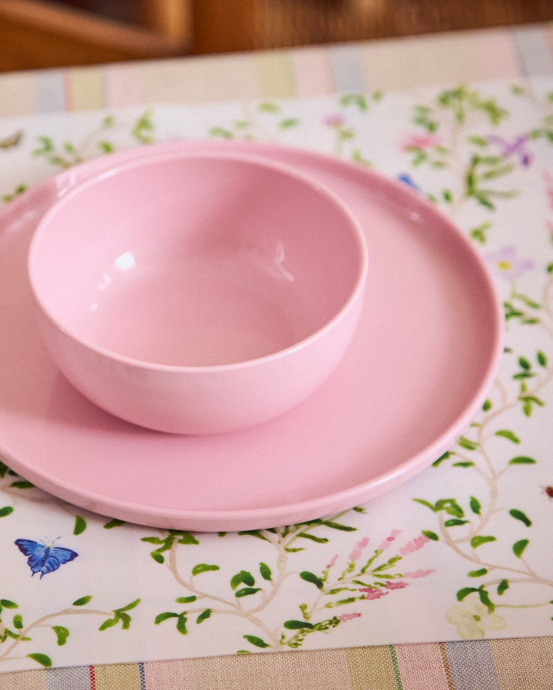 Pink bowl and plate set on a floral tablecloth
