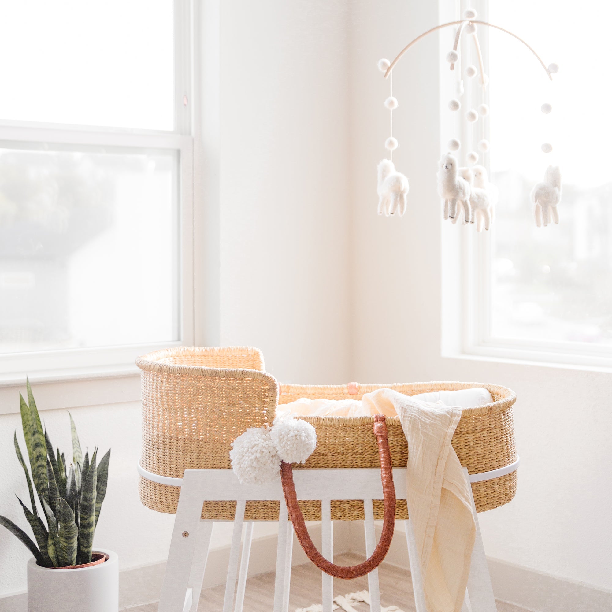 Nursery room with a wicker crib, white stool, and decorative elements.
