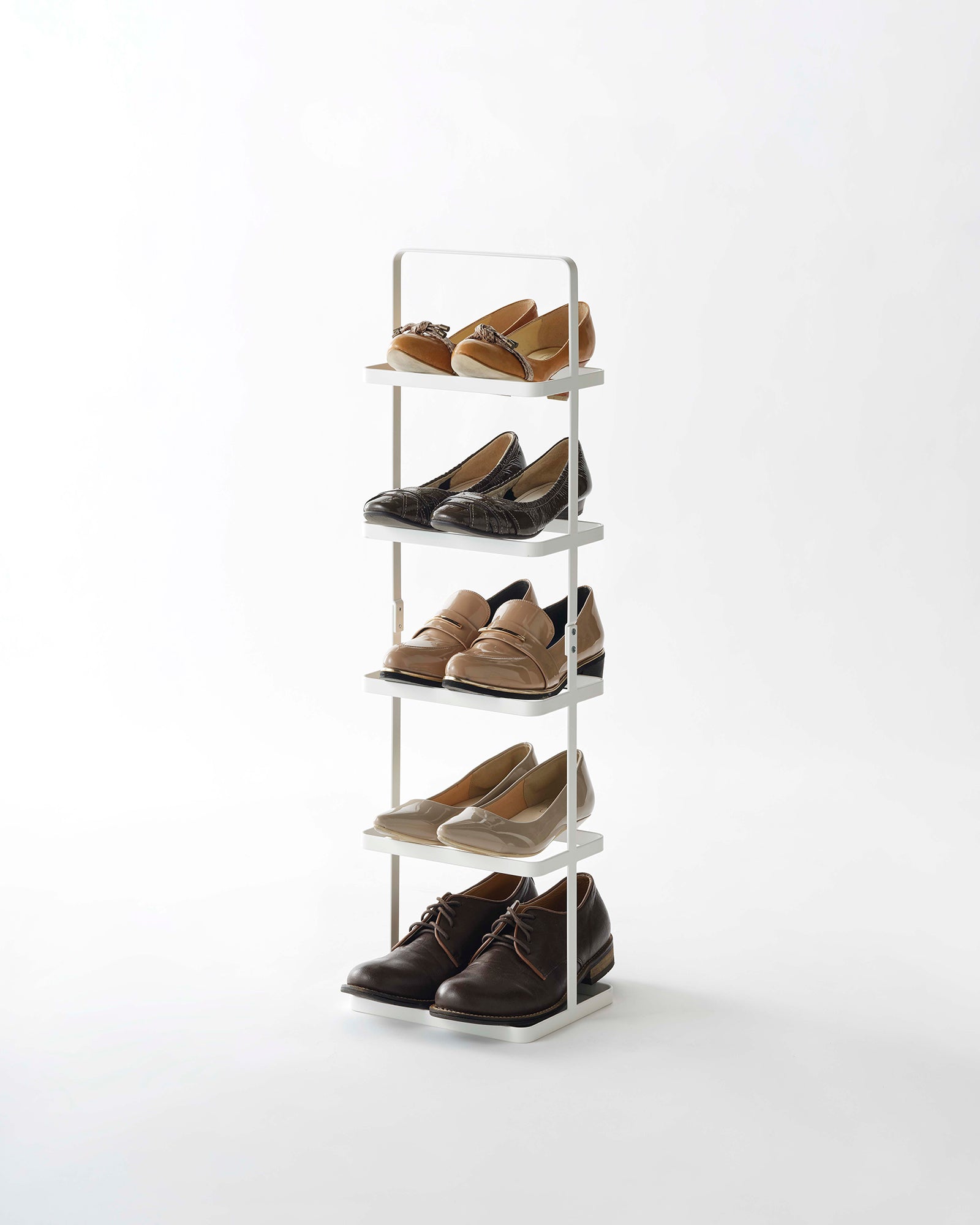 Shoe rack with five pairs of shoes on a white background