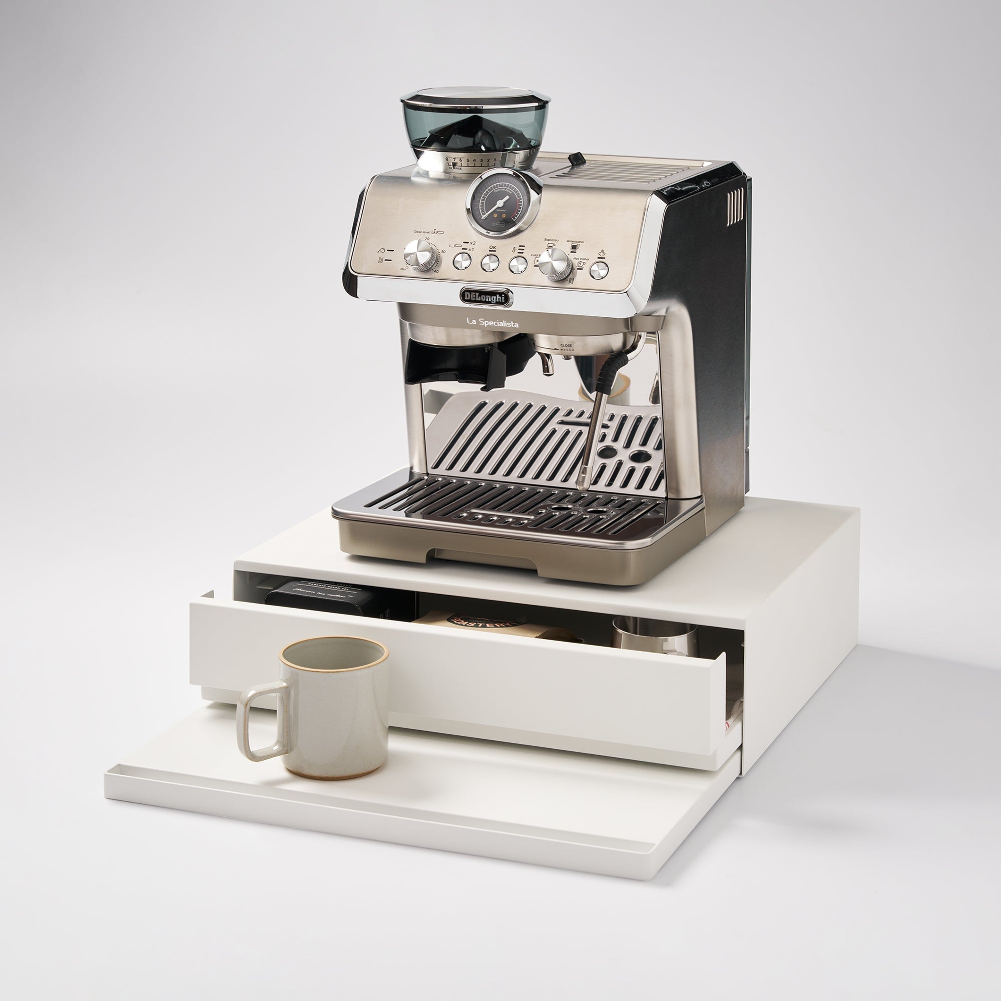 Espresso machine with a drawer and a cup on a white background