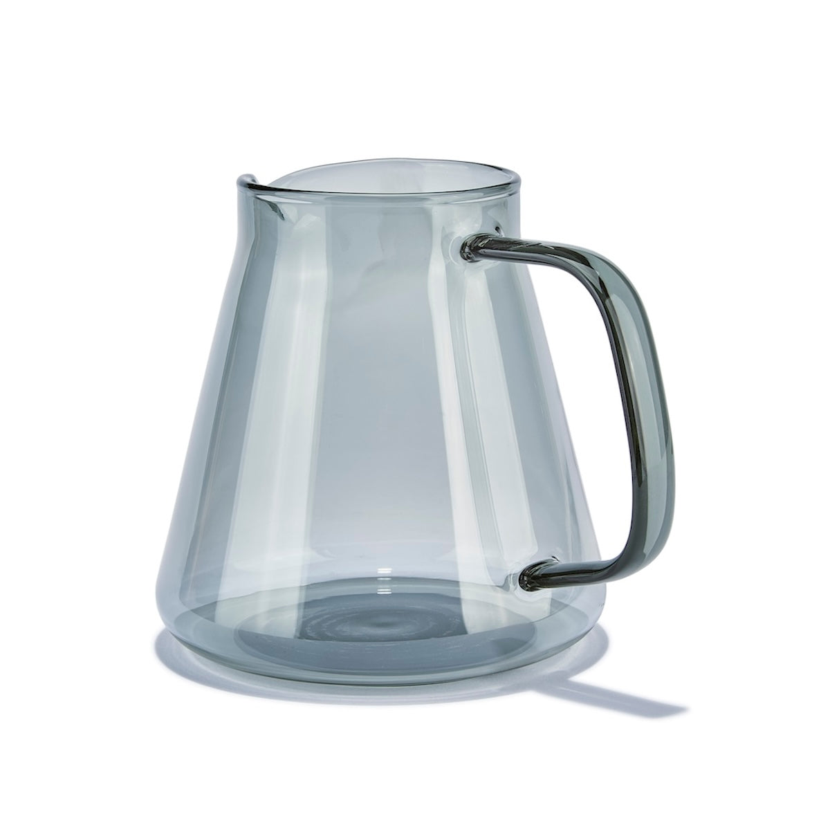 Clear glass pitcher with black handle on a white background