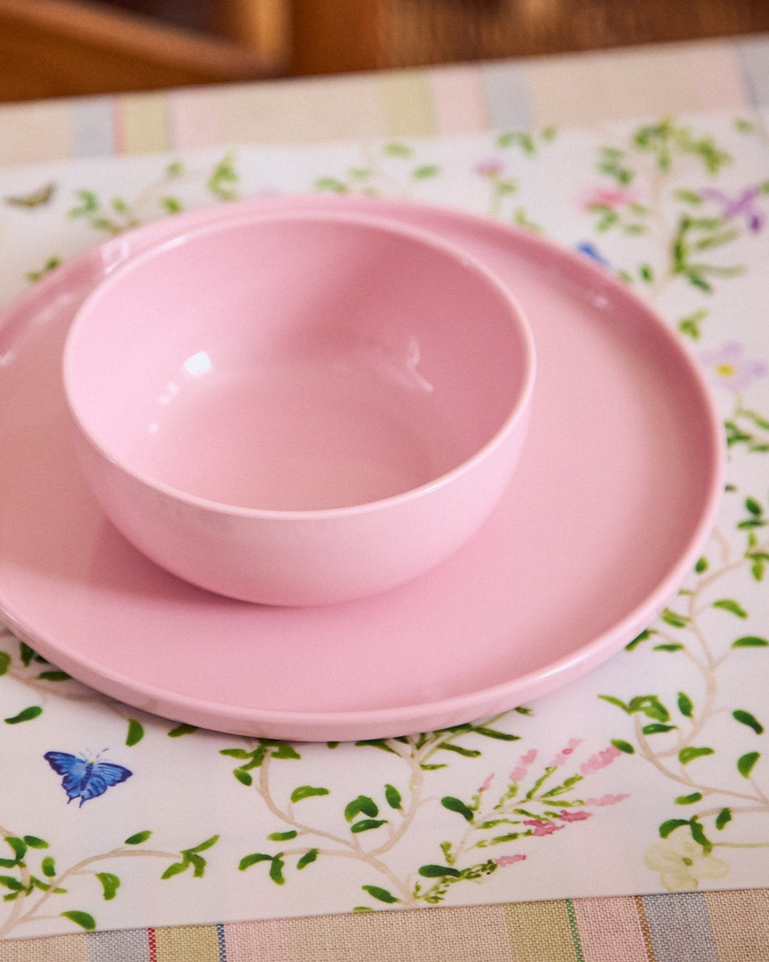 Pink bowl and plate set on a floral placemat