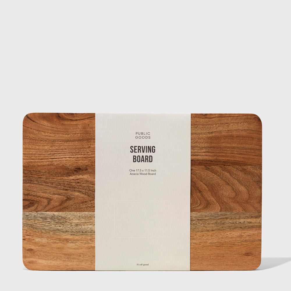Wooden serving board with 'Public Goods' label on a white background