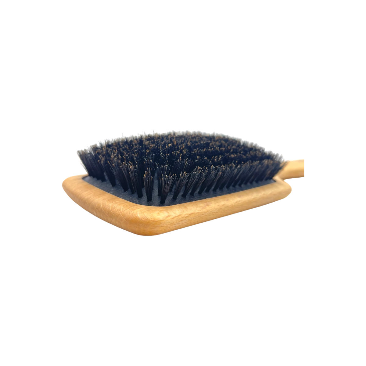 Hairbrush with black bristles on a wooden handle against a white background