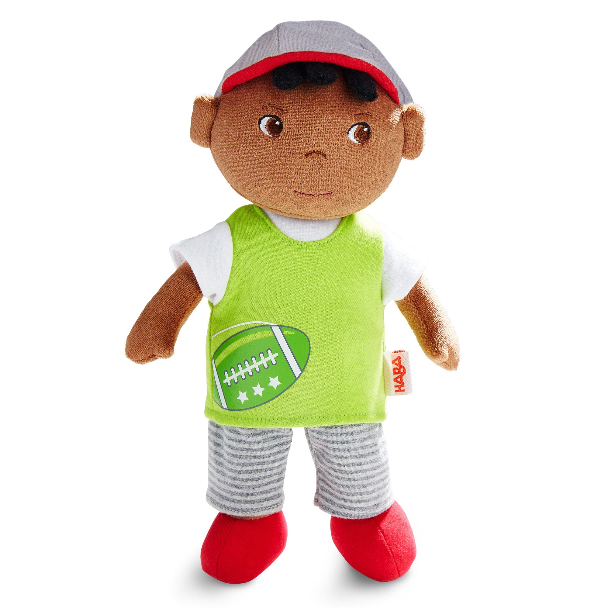 Plush toy with a child wearing a green jersey with a football design, gray cap, and red shoes on a white background.