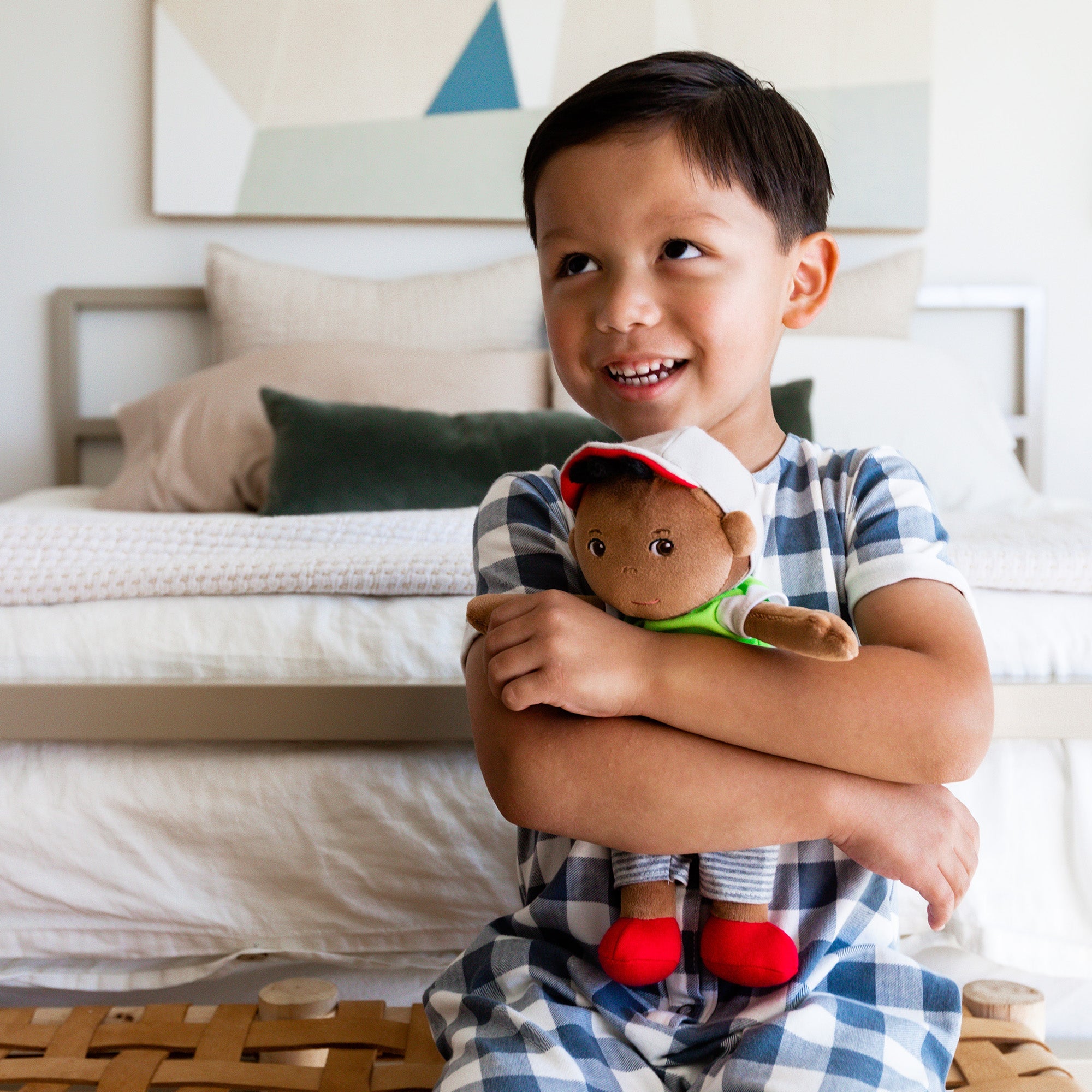 Child holding a teddy bear in a bedroom setting