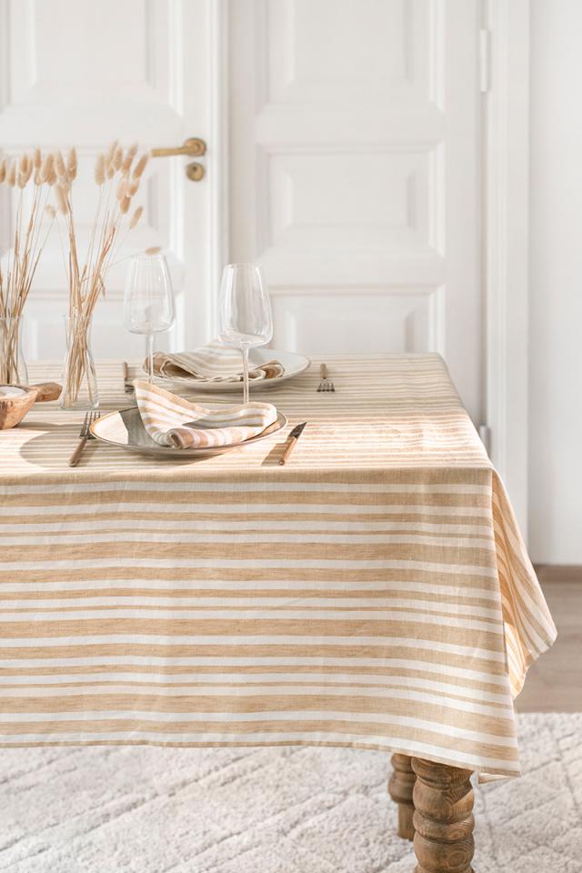 Table setting with a striped tablecloth in a softly lit room.