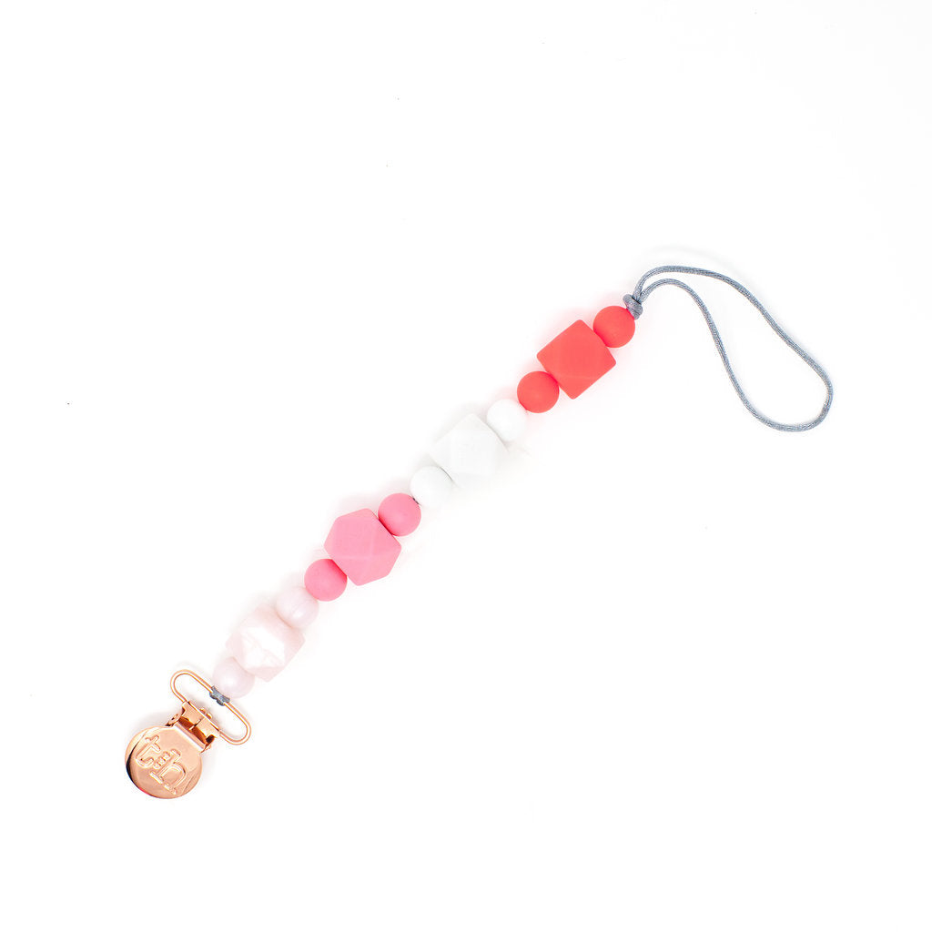 Pacifier clip with pink and white beads and a gold clasp on a white background