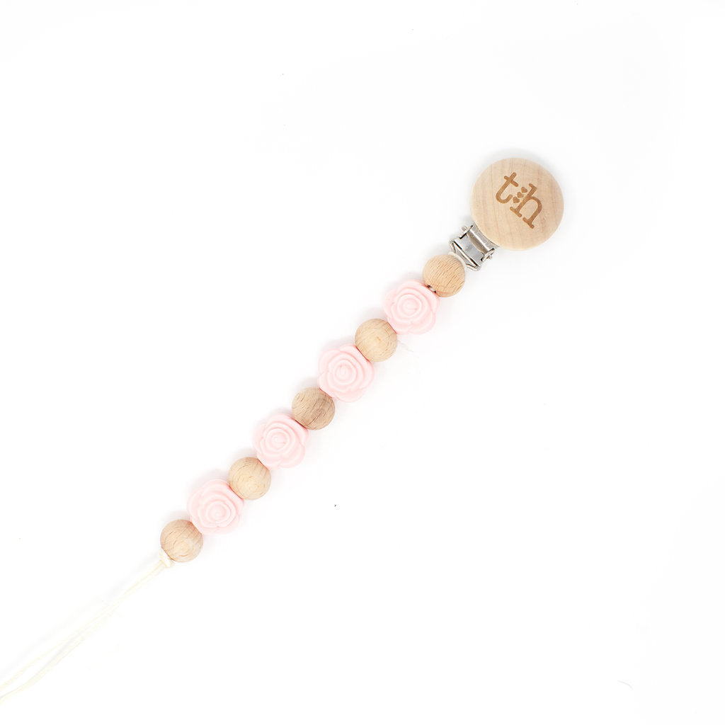 Beaded pacifier clip with pink and wooden beads on a white background