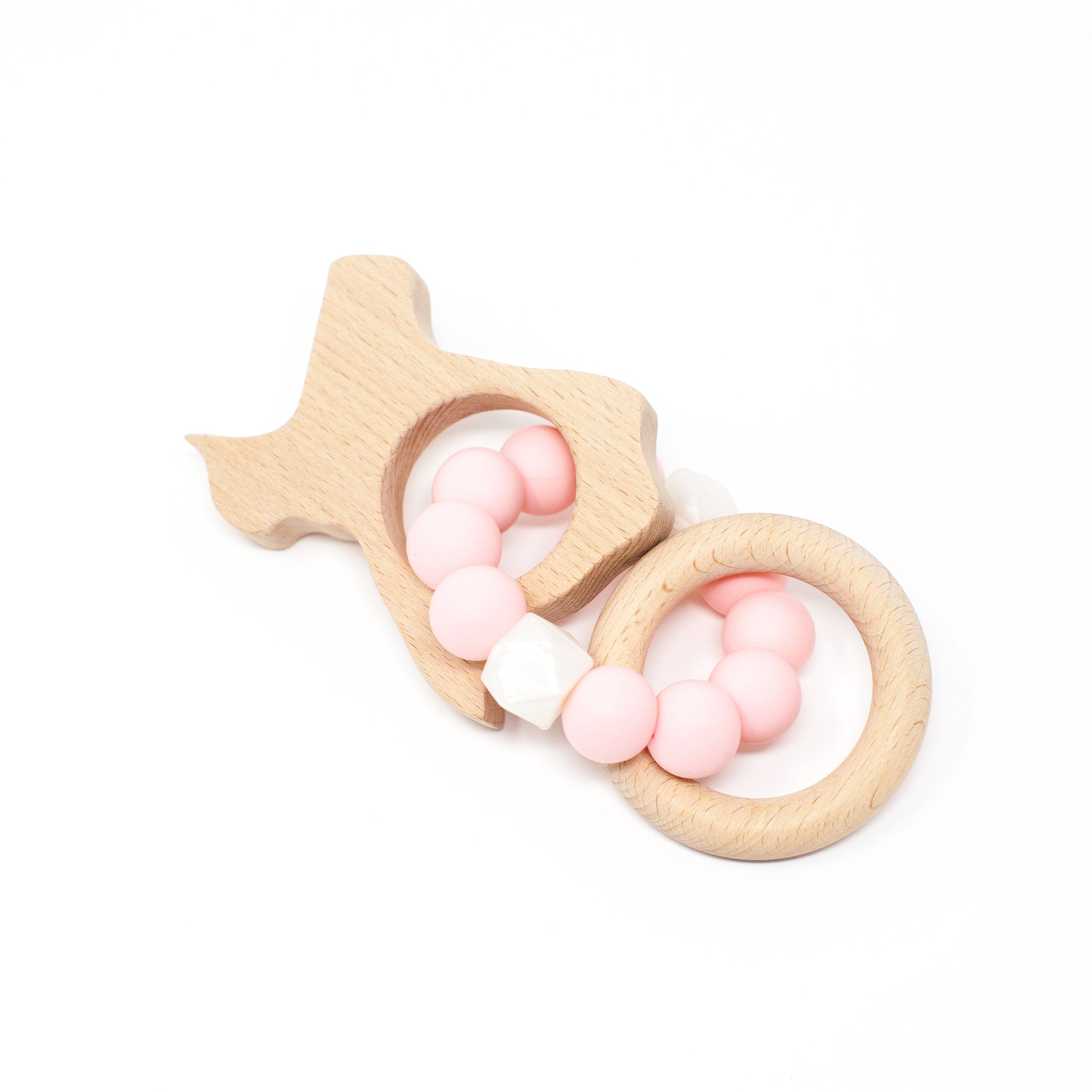 Wooden fish-shaped teething ring with pink and white beads on a white background