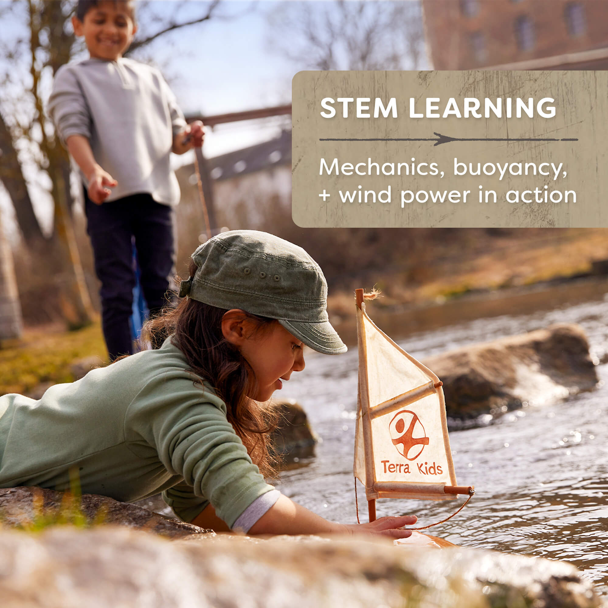 Child playing with a sailboat by a stream, with 'Terra Kids' branding.