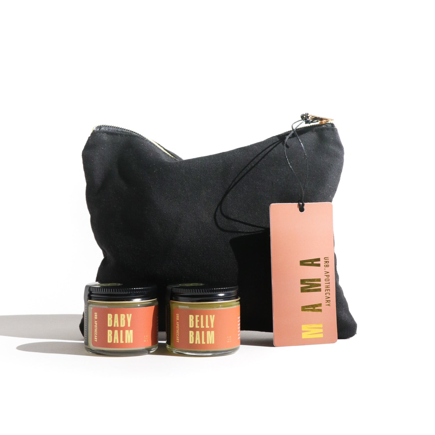 Black bag with two jars of balm and a pink card labeled 'MAMA' on a white background