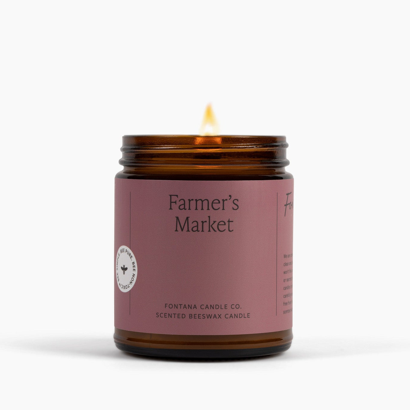 Candle in a glass jar labeled 'Farmer's Market' by Fontana Candle Co. on a white background