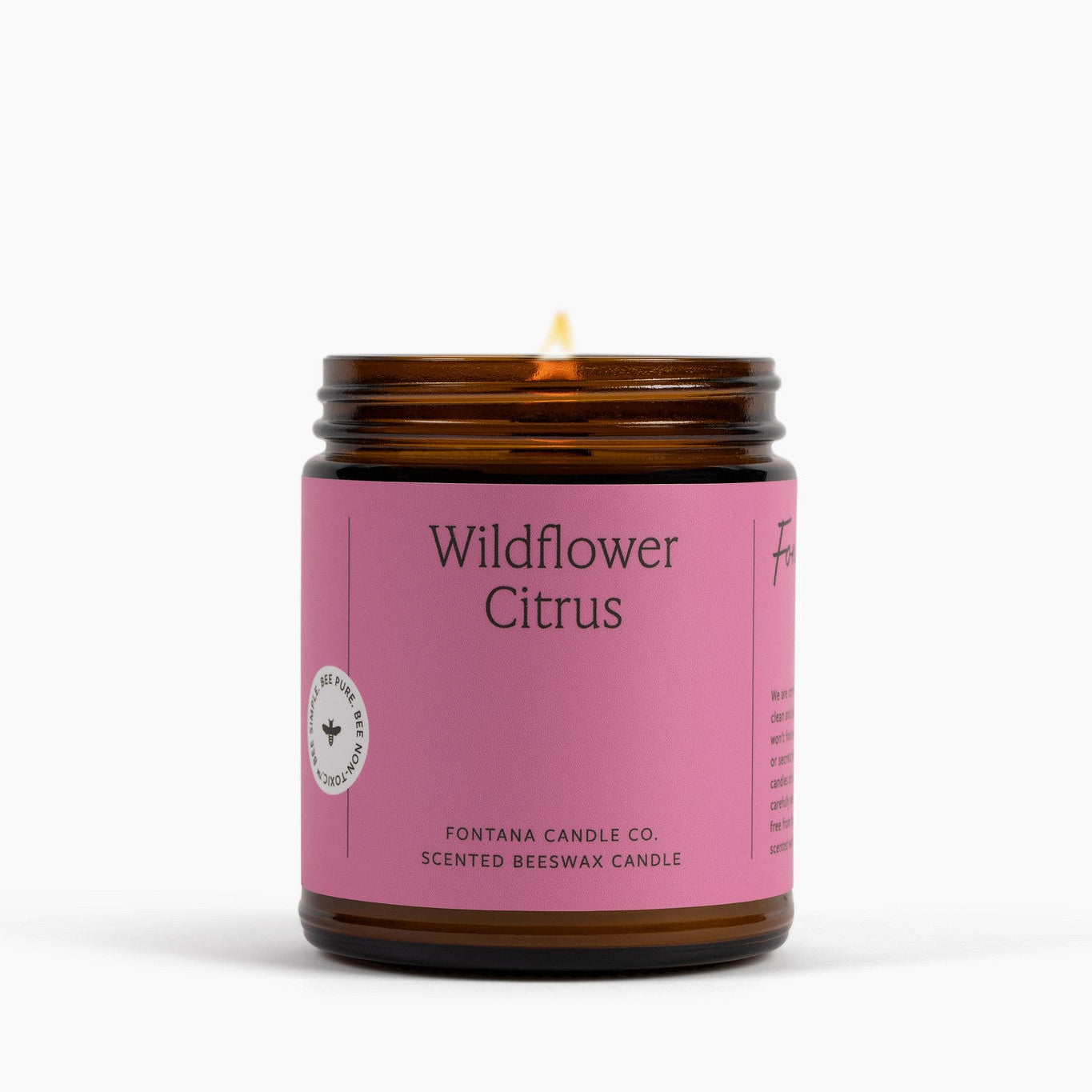 Candle with a pink label reading 'Wildflower Citrus' on a white background