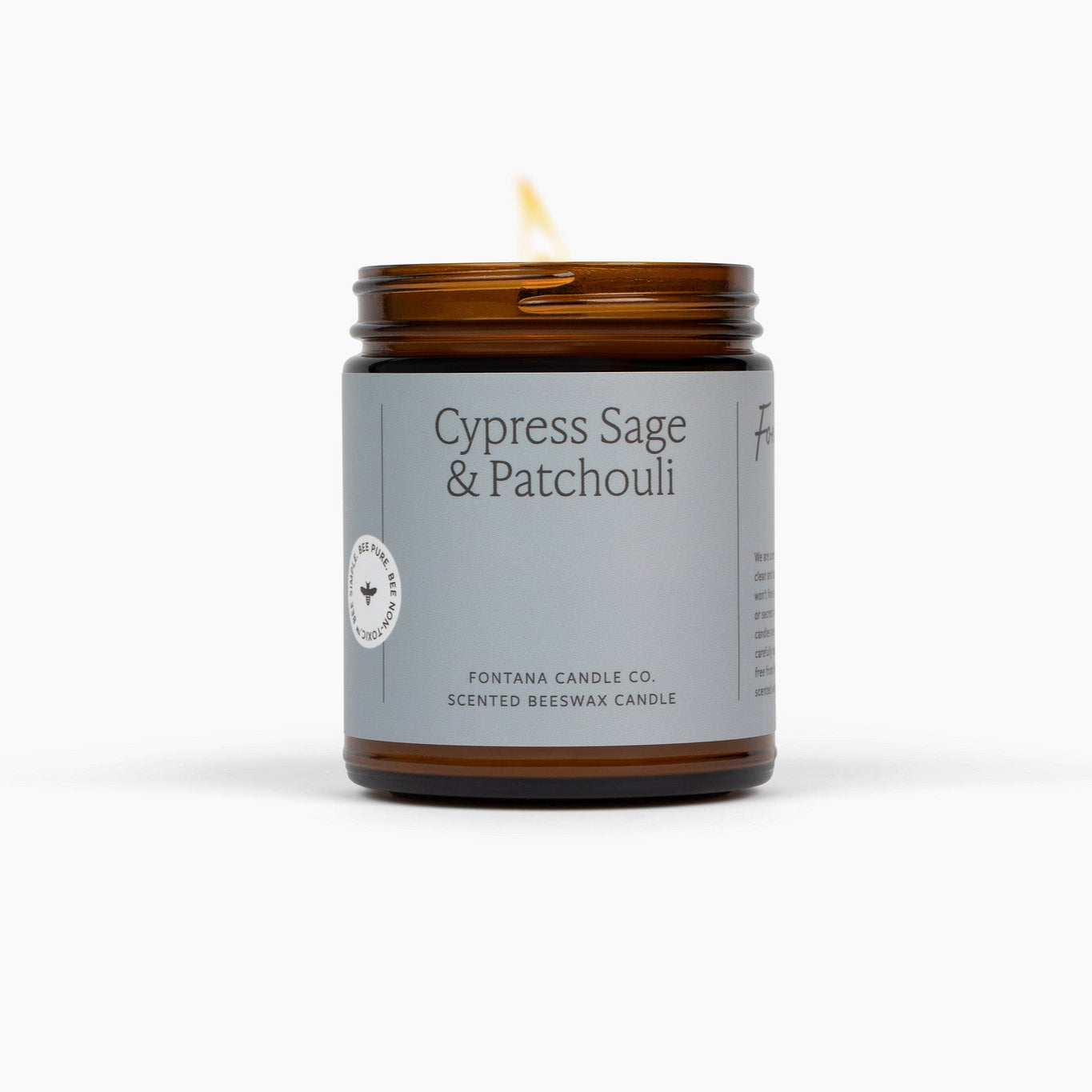 Candle with a gray label featuring 'Cypress Sage & Patchouli' on a white background