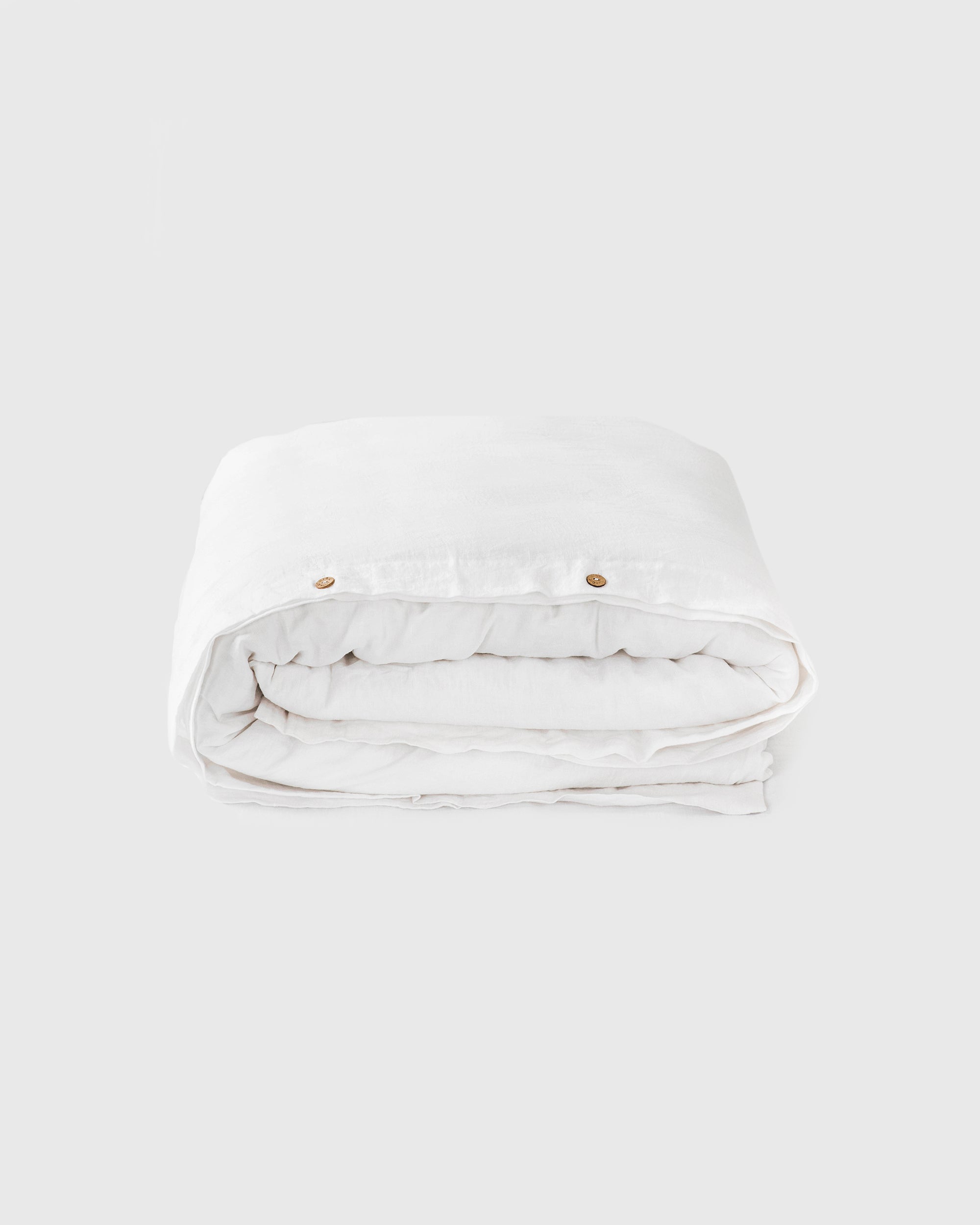 White quilt folded on a light gray background