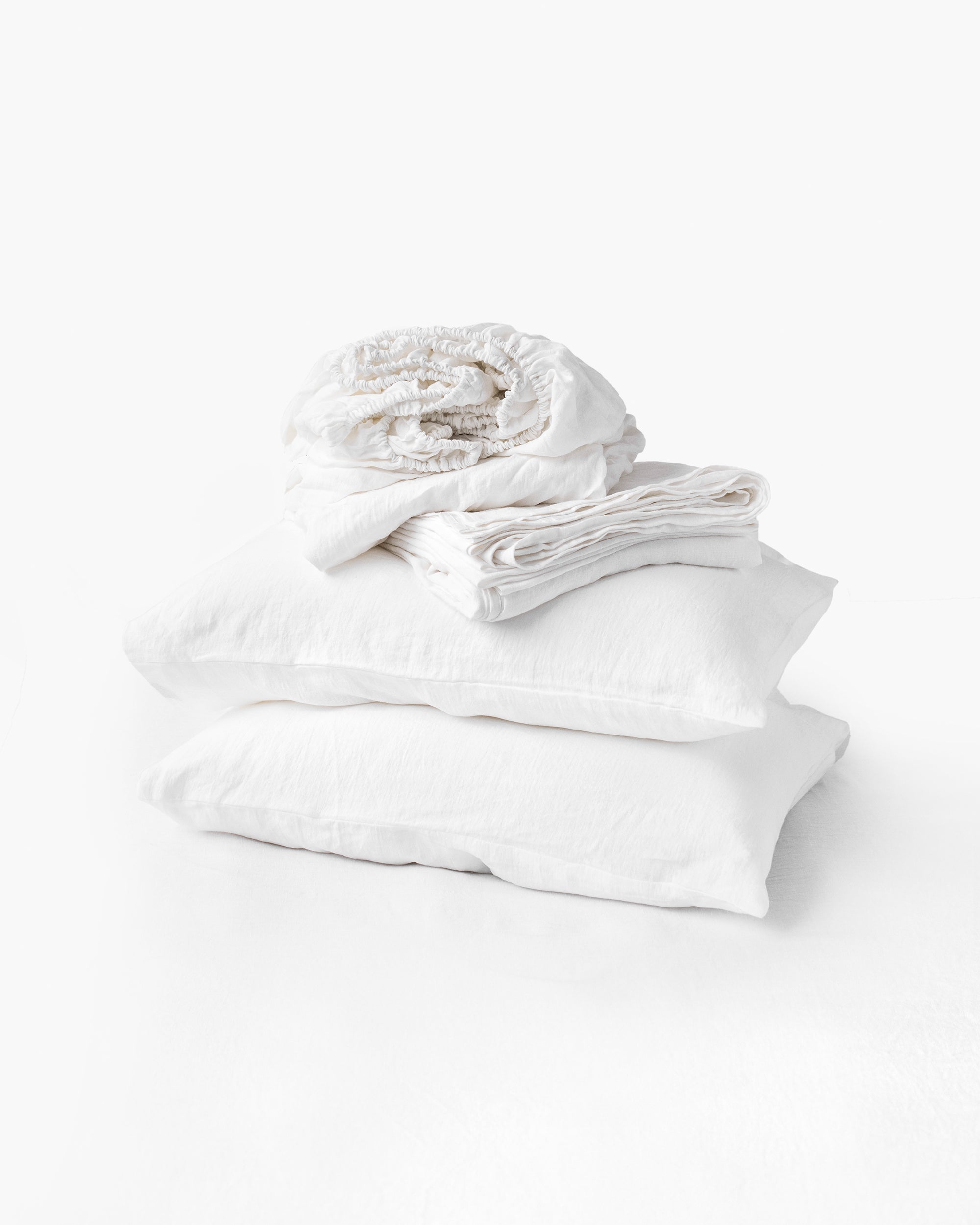 Stack of white folded clothes on a white background