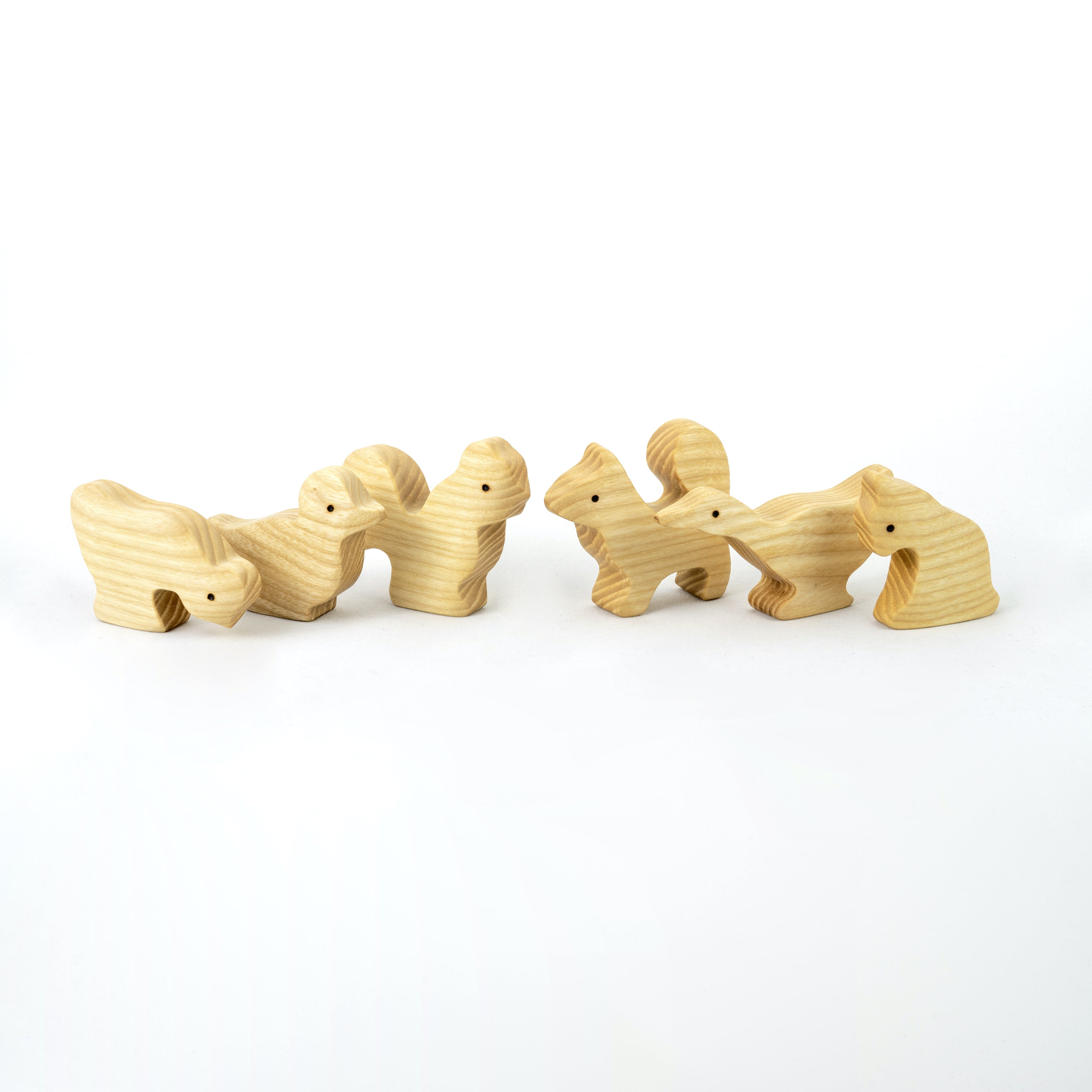 Set of four wooden animal toys on a white background