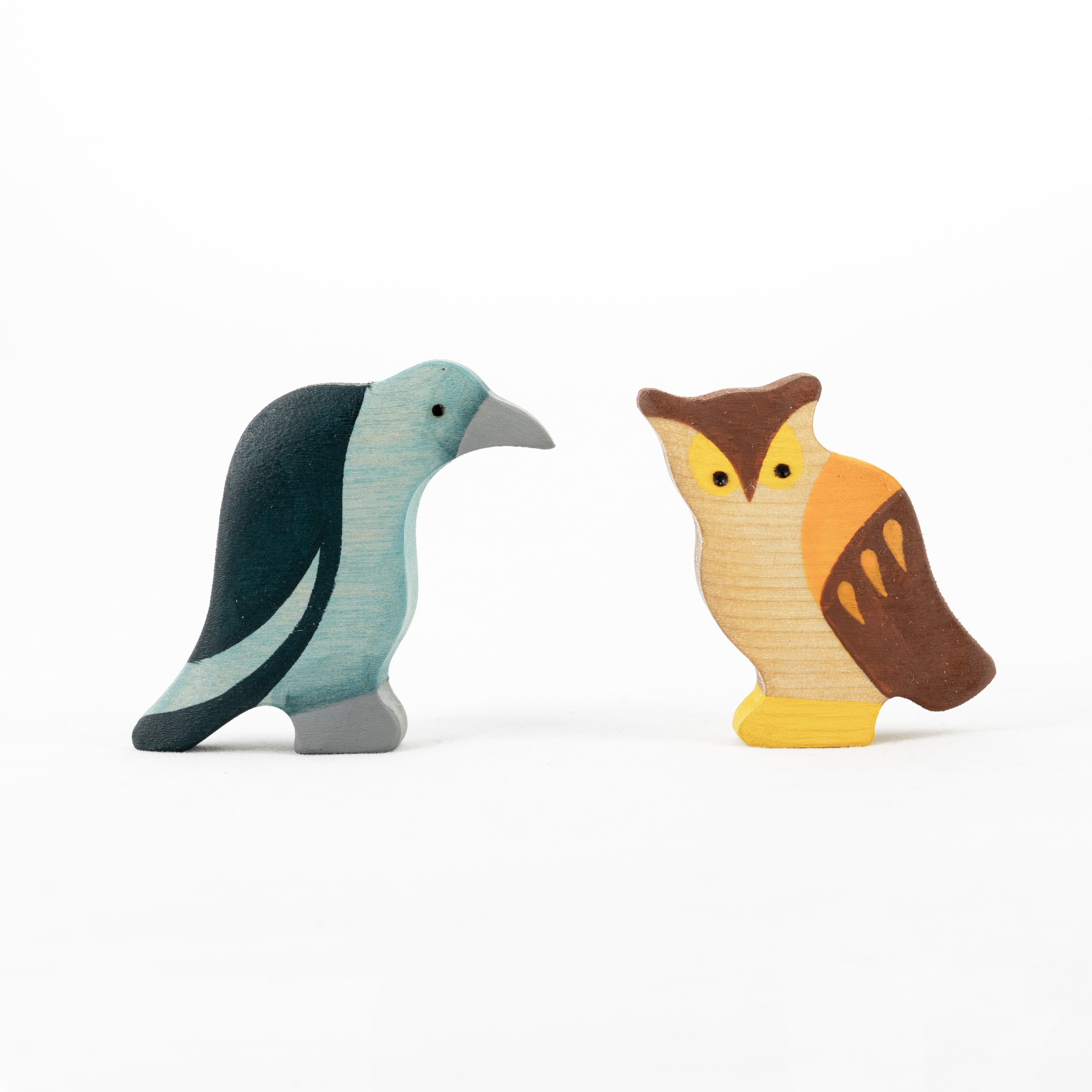 Two wooden bird figurines on a white background