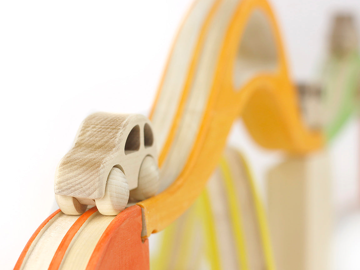 Wooden toy car on a wooden track with a blurred background