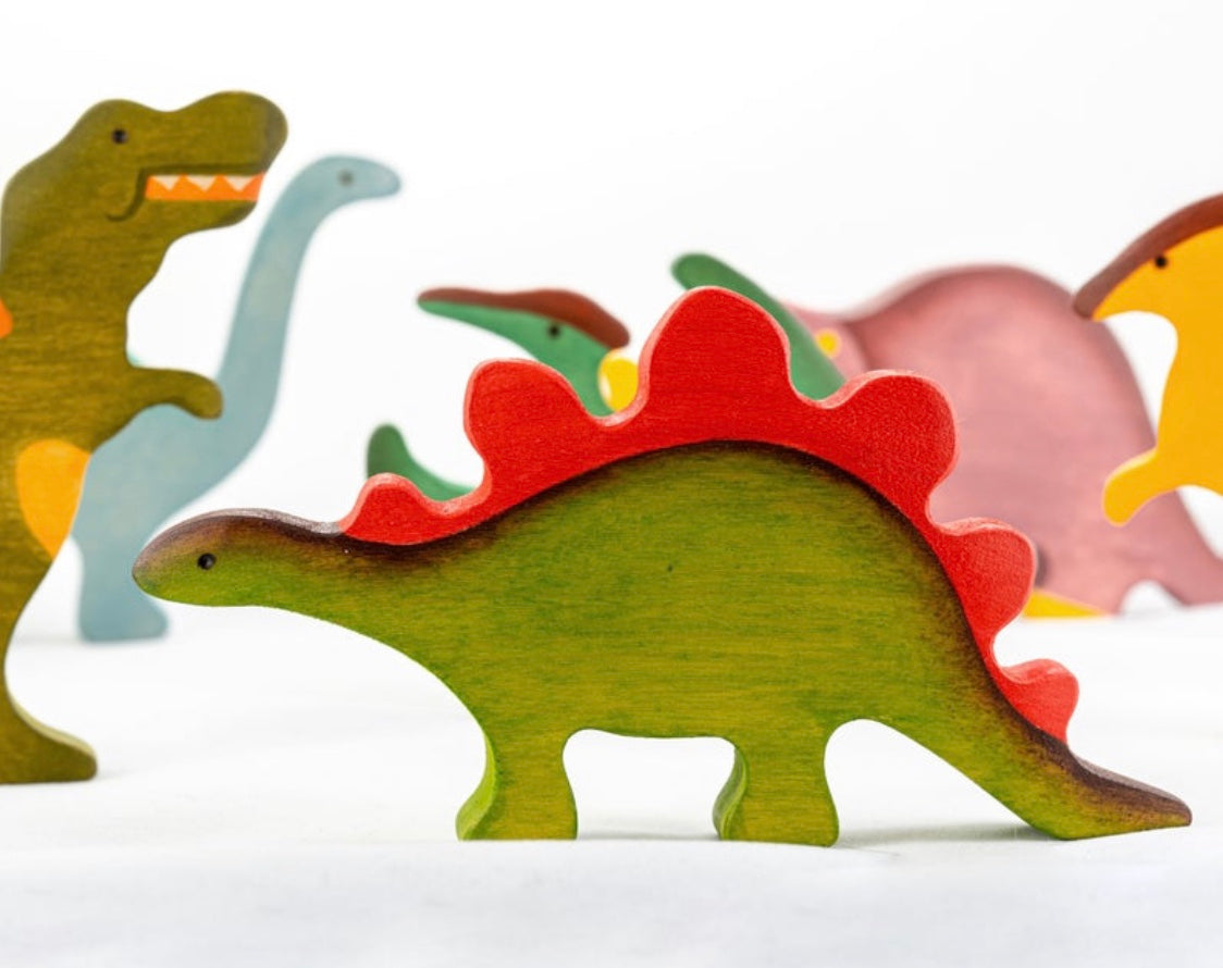 Colorful wooden dinosaur toys on a white background