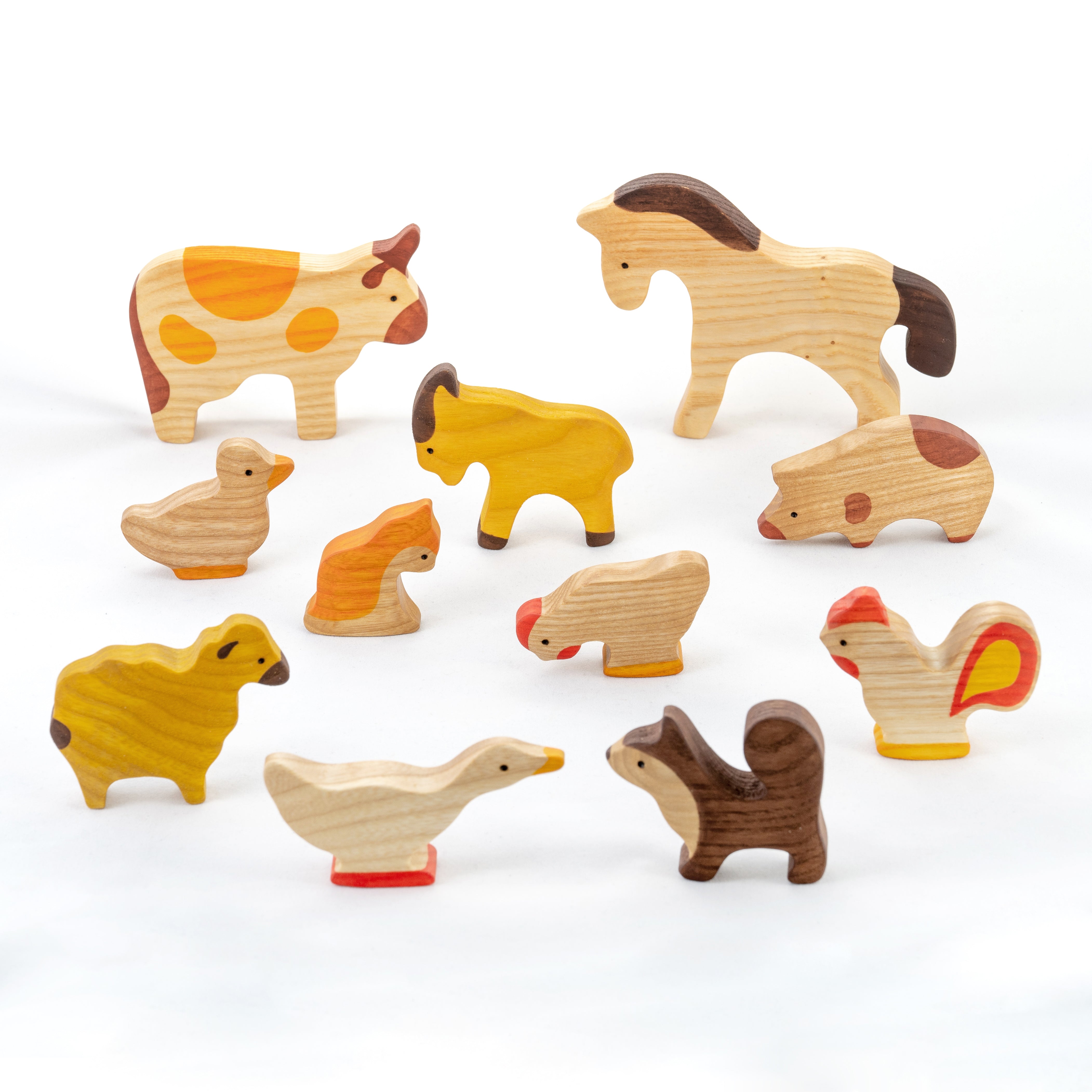 Set of wooden farm animal toys on a white background