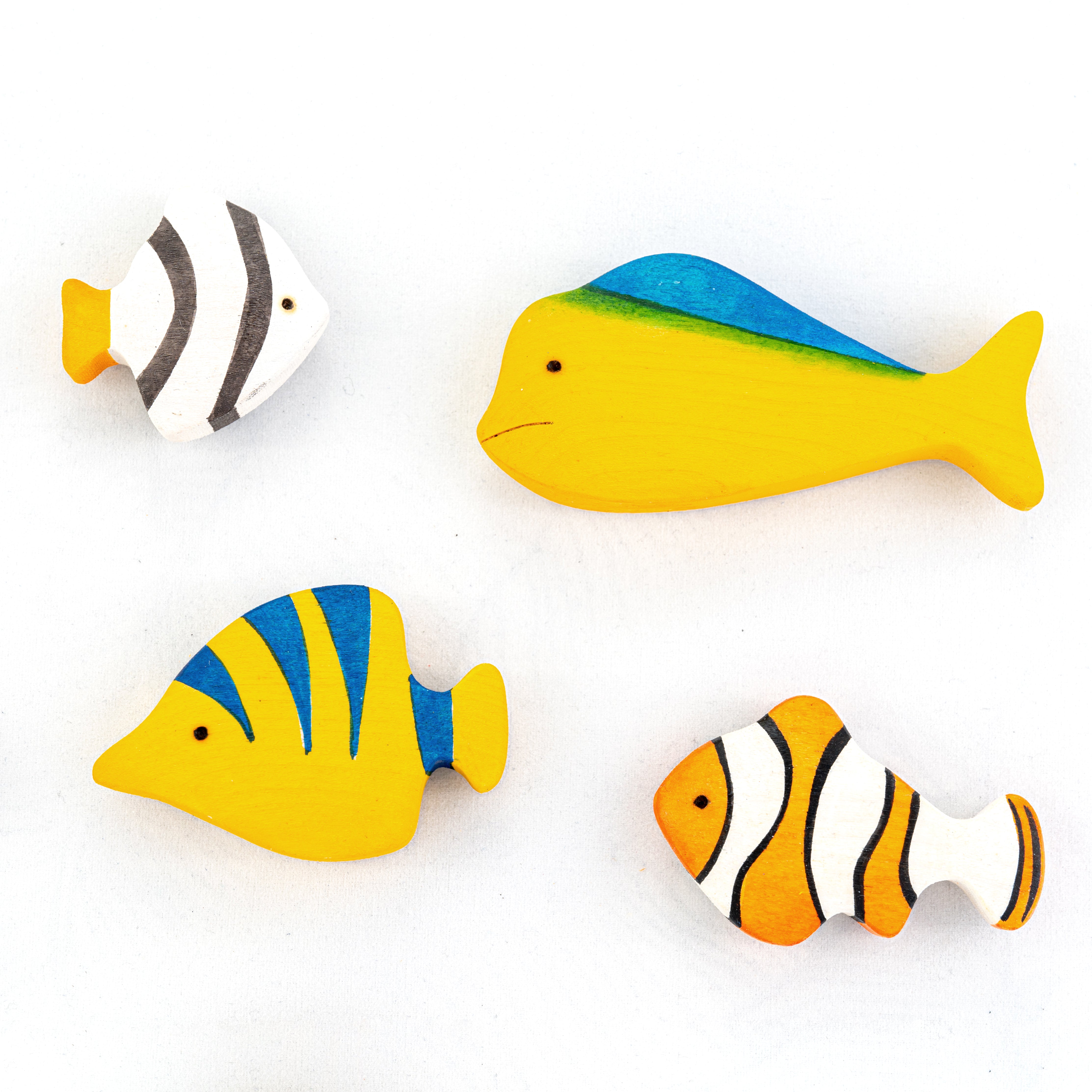 Set of colorful fish-shaped wooden toys on a white background