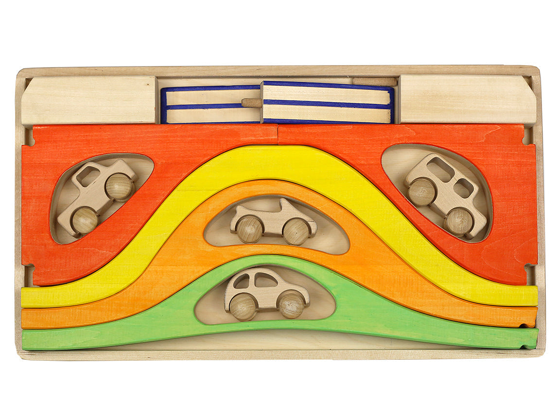 Wooden toy with colorful wavy design and cut-out shapes for cars on a white background