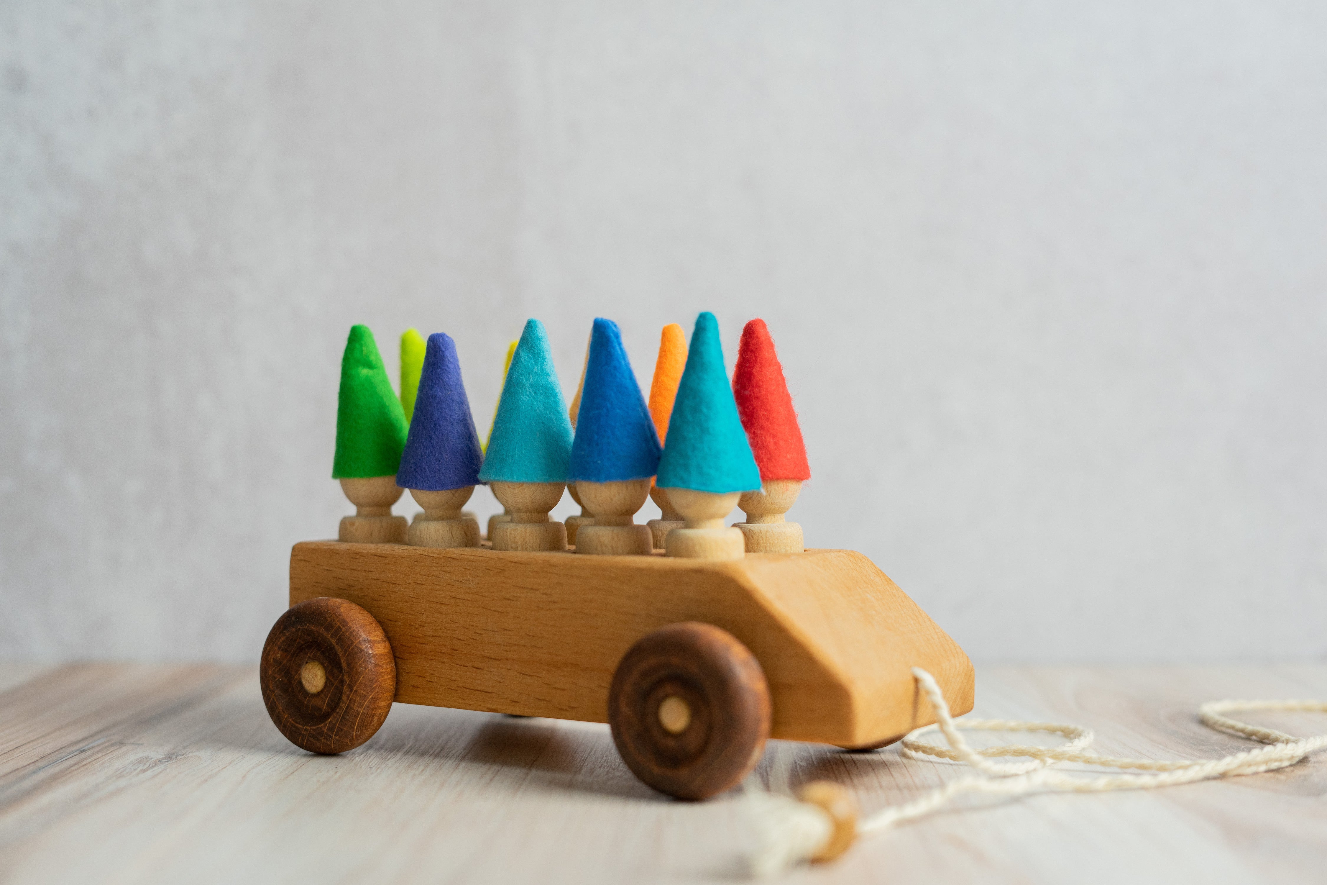 Wooden toy car with colorful geometric shapes on a light background