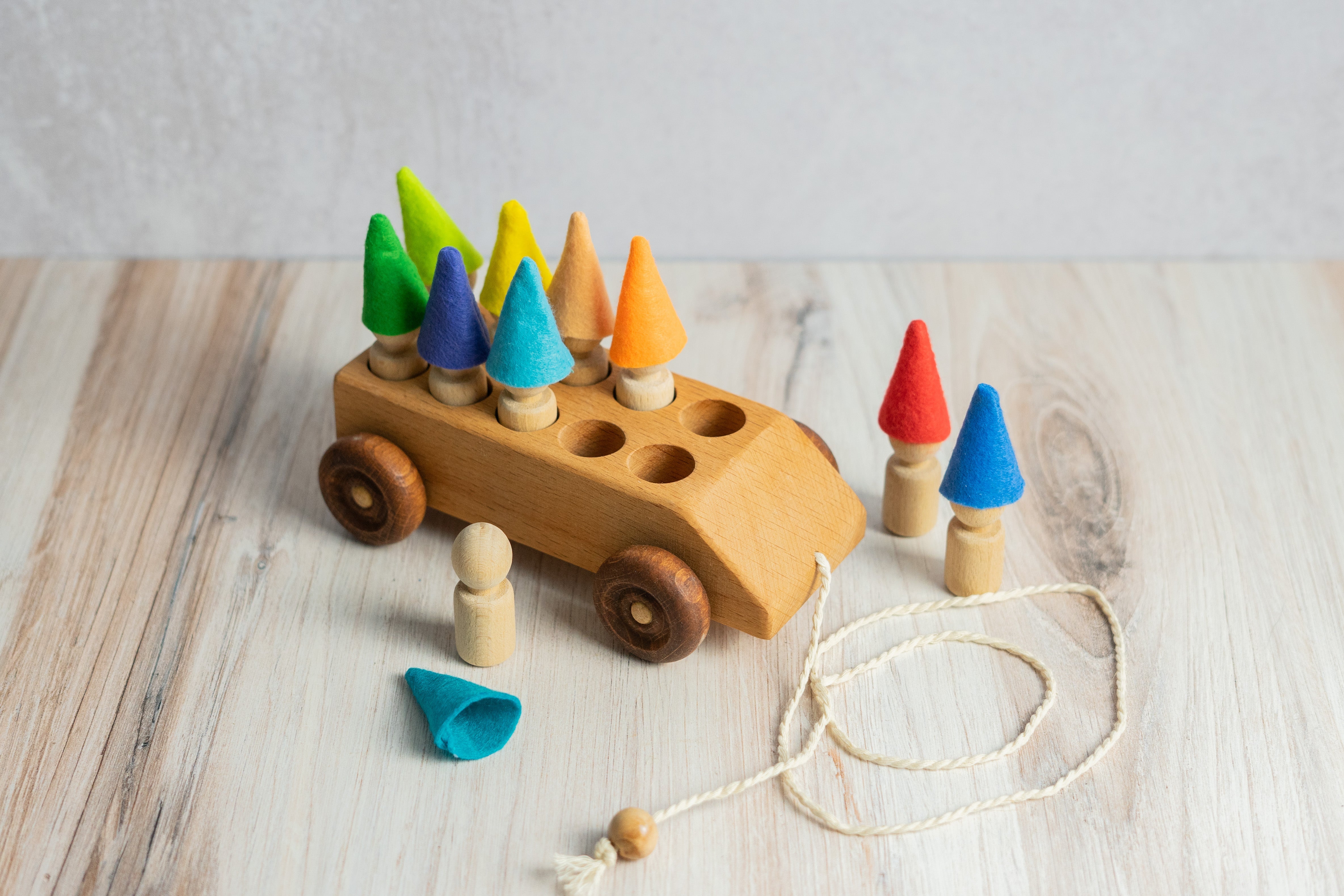 Wooden toy with colorful cone-shaped figures on a light wooden surface
