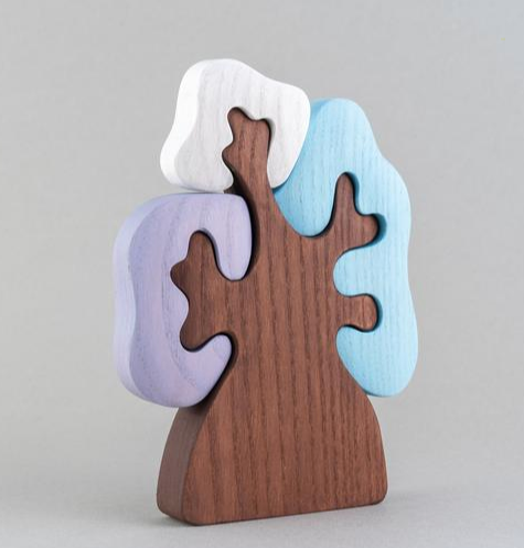 Wooden puzzle piece with a gradient of colors on a gray background