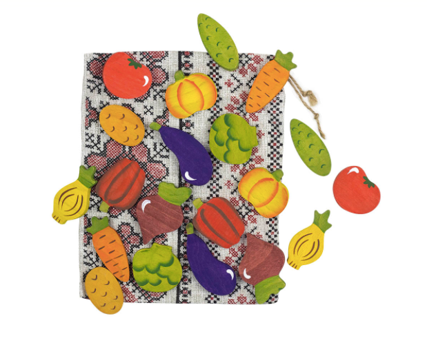 Colorful vegetable-shaped door stopper on a checkered fabric background