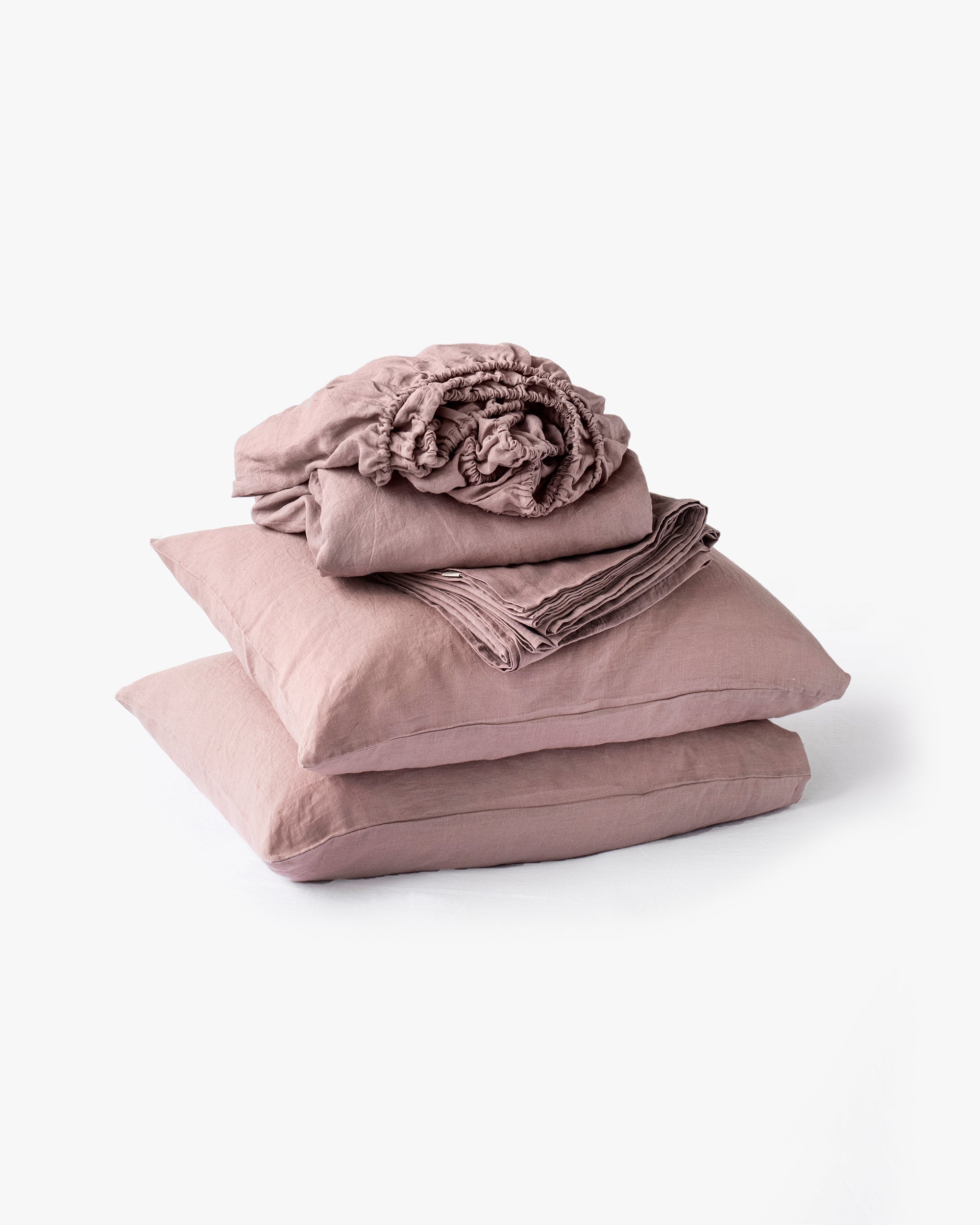 Stack of pink bedding with a flower on a white background