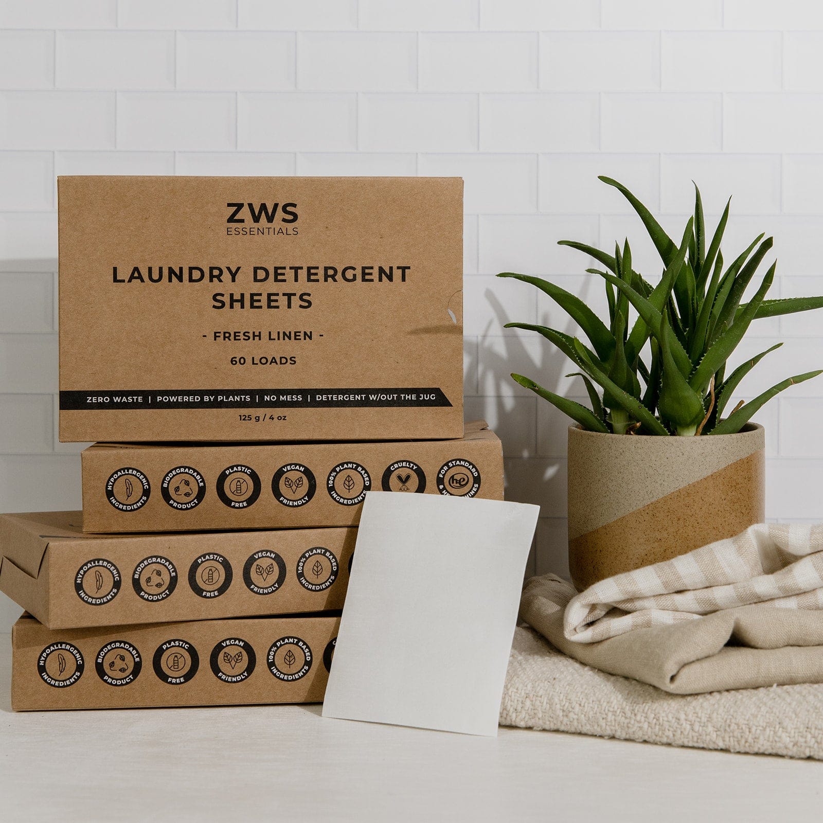 ZWS laundry detergent sheets packaging with a plant and folded fabric on a light background