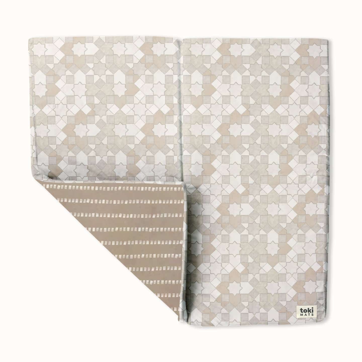 A baby play mat with a grey mosaic cover.