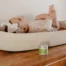 A baby lying in a bassinet next to a jar of Earth Mama Organic Diaper Balm
