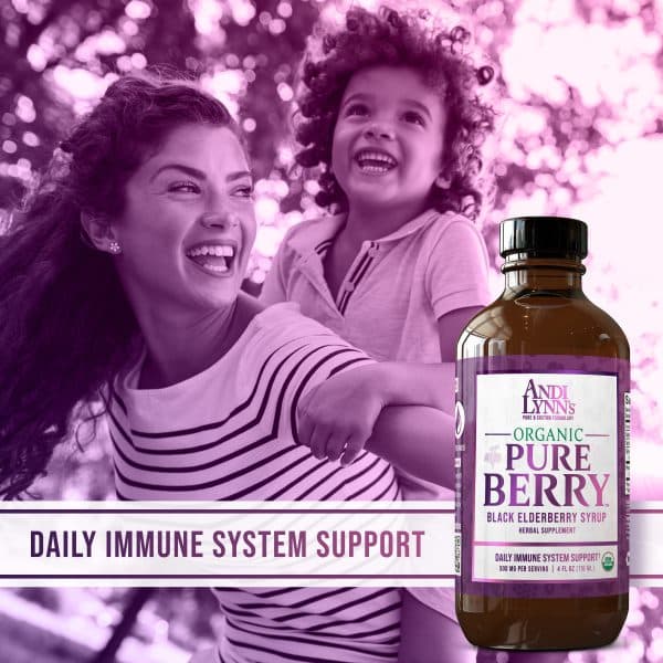 A woman holding her child on her back and laughing in the sunlight. In the foreground is a banner reading Daily Immune Support and a bottle of Andi Lynn's - Pure Black Elderberry Syrup