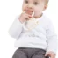 A young baby sitting and chewing on a sophie la girafe natural rubber teether.