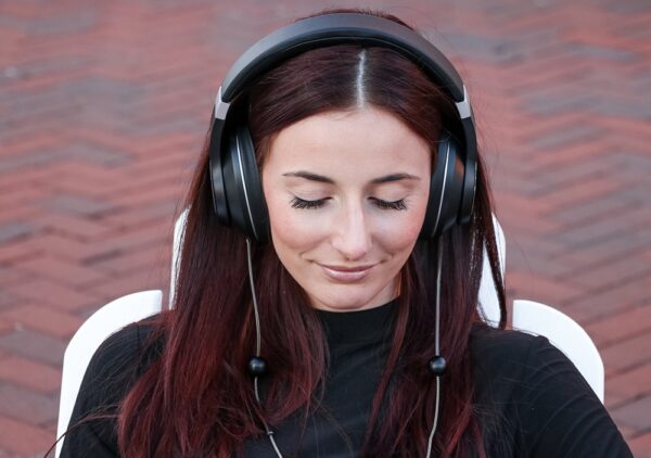 A woman smiling and wearing A man standing outside wearing EMF Radiation-Free Air Tube Over-Ear Headphones.