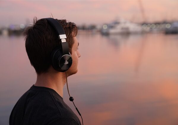A man standing outside wearing DefenderShield EMF Radiation-Free Air Tube Over-Ear Headphones.