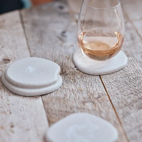 A wooden table with a white coaster set