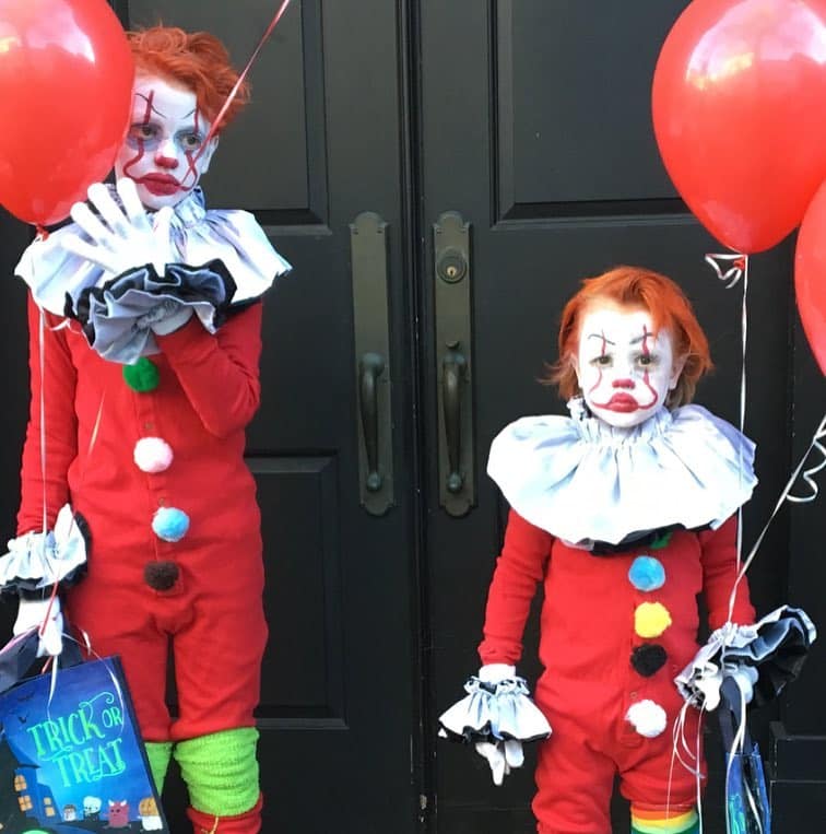 Healthy Halloween with kids dressed as clowns holding balloons