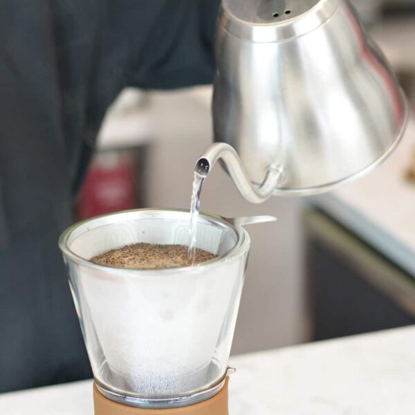Woman brewing fresh coffee with Grosche Amsterdam Glass Pour Over Coffee Maker from Gimme the Good Stuff 001